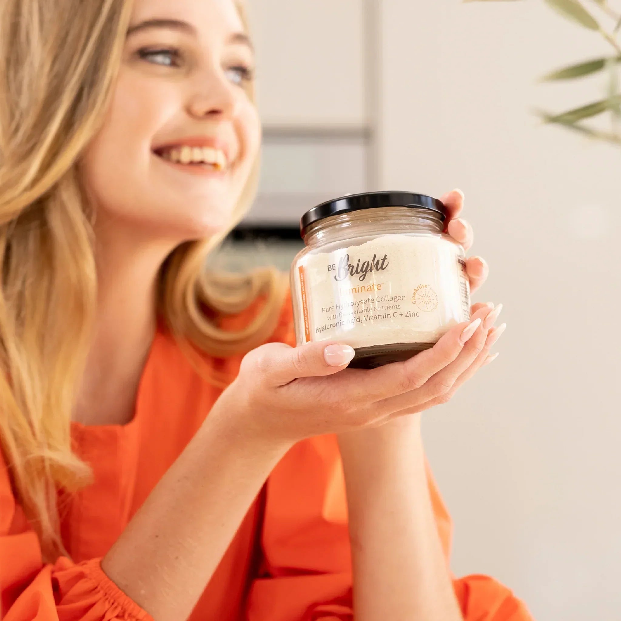 Be Bright Luminate Collagen Powder Jar 280g for Radiant Skin held by a woman, showcasing luxury skincare benefits.