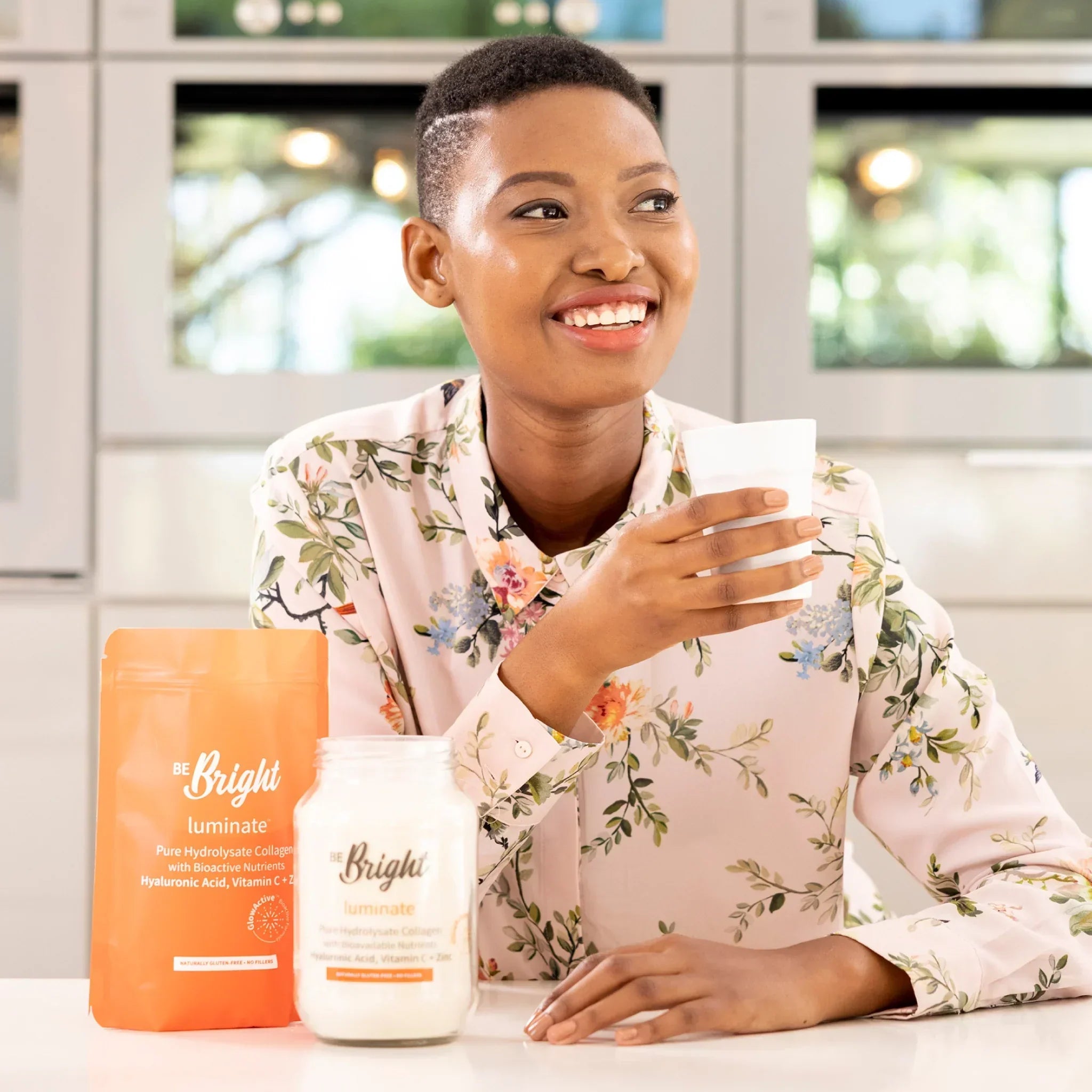 Be Bright Luminate: Hydrolyzed Collagen for Radiant Skin & Wellness. Woman drinking beverage near collagen powder.