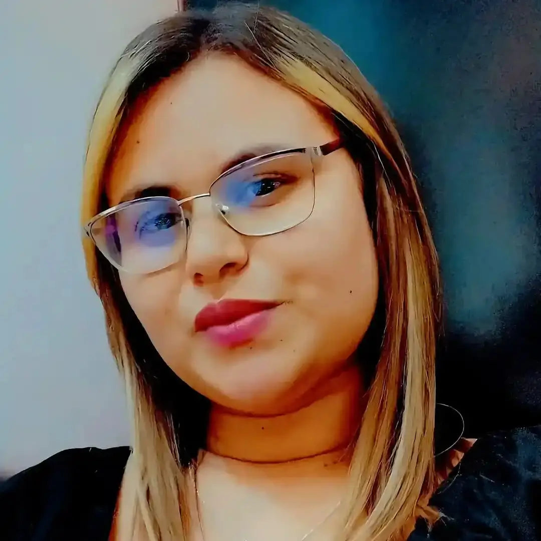 A close-up portrait showing glasses, red lipstick, and blonde hair.