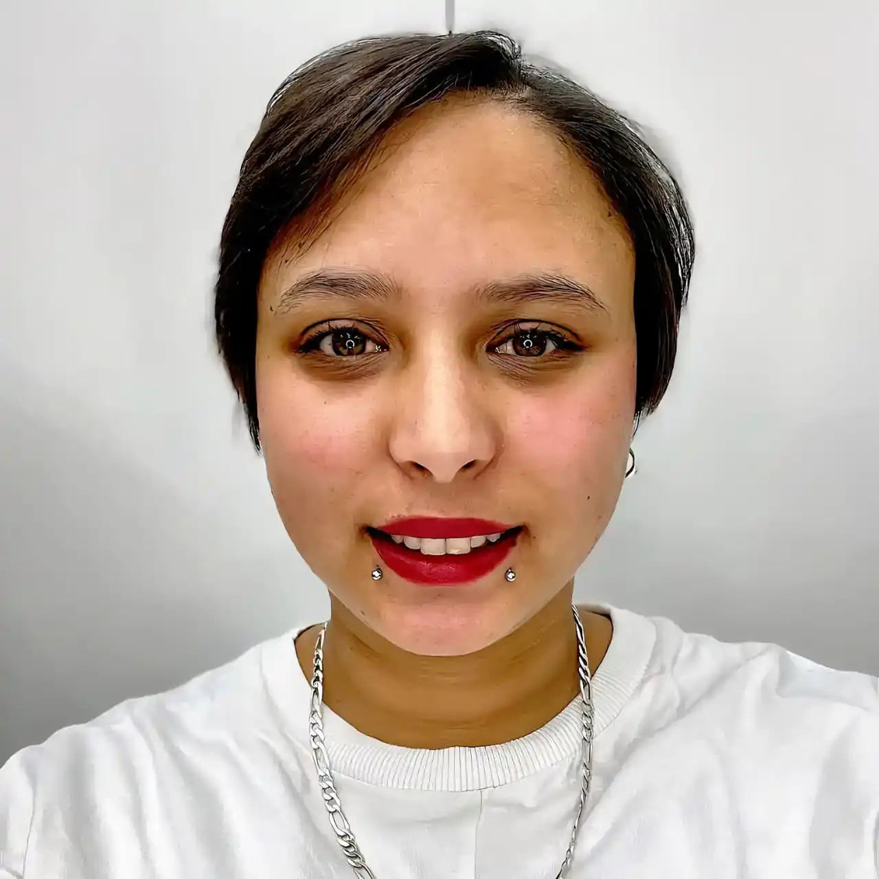A close-up selfie portrait showing bright red lipstick and a white top.