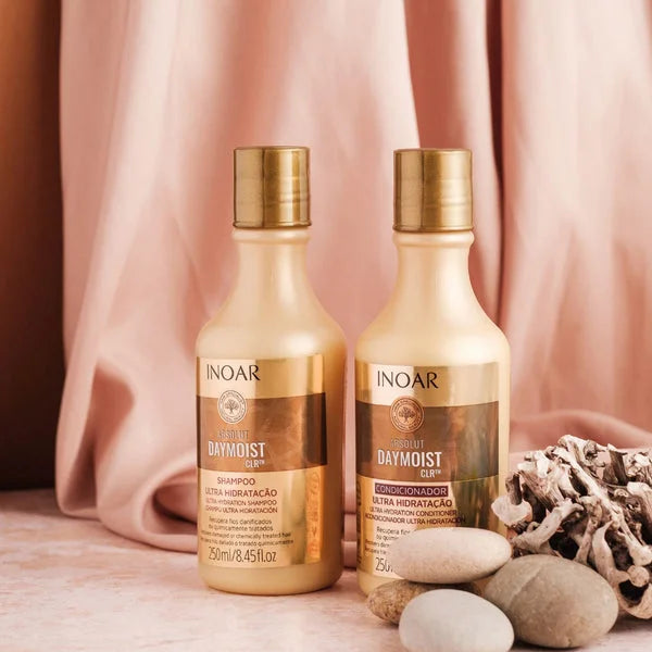 Inoar Absolut Daymoist Shampoo and conditioner bottles with gold caps on display