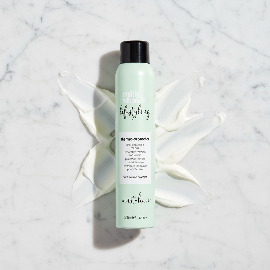 Milkshake heat protection spray for hair in a light green bottle on white cream background