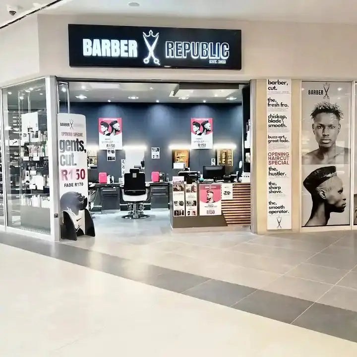 Modern barbershop storefront with illuminated ’Barber Republic’ signage.