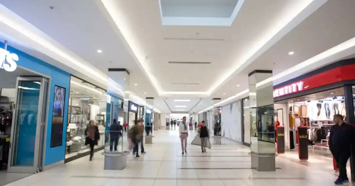 Modern shopping mall corridor with bright LED lighting in the ceiling.