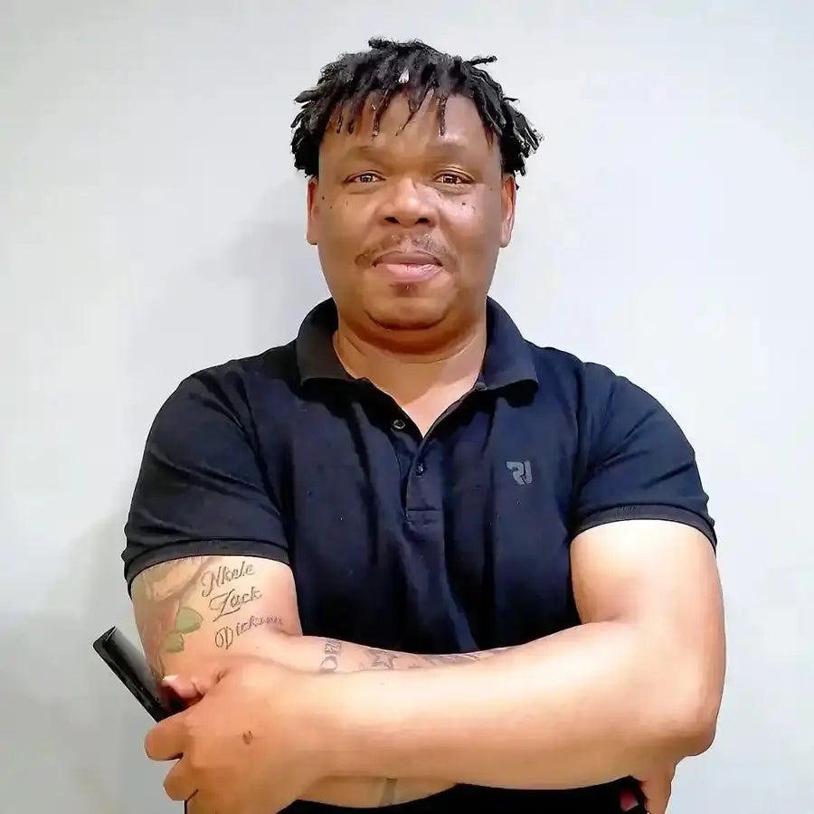 Someone wearing a navy blue polo shirt with a visible arm tattoo.