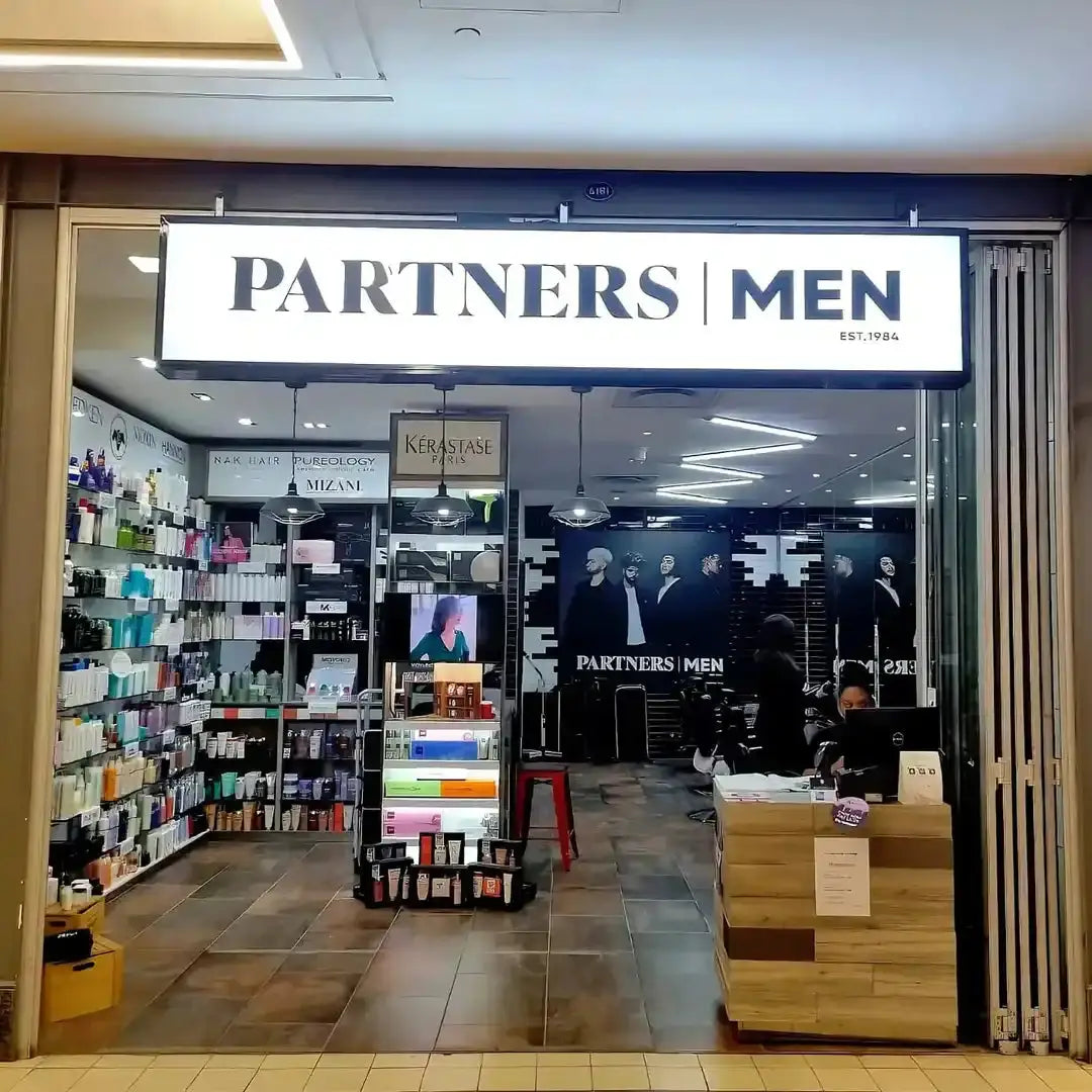 Partners Men retail store storefront with illuminated signage.