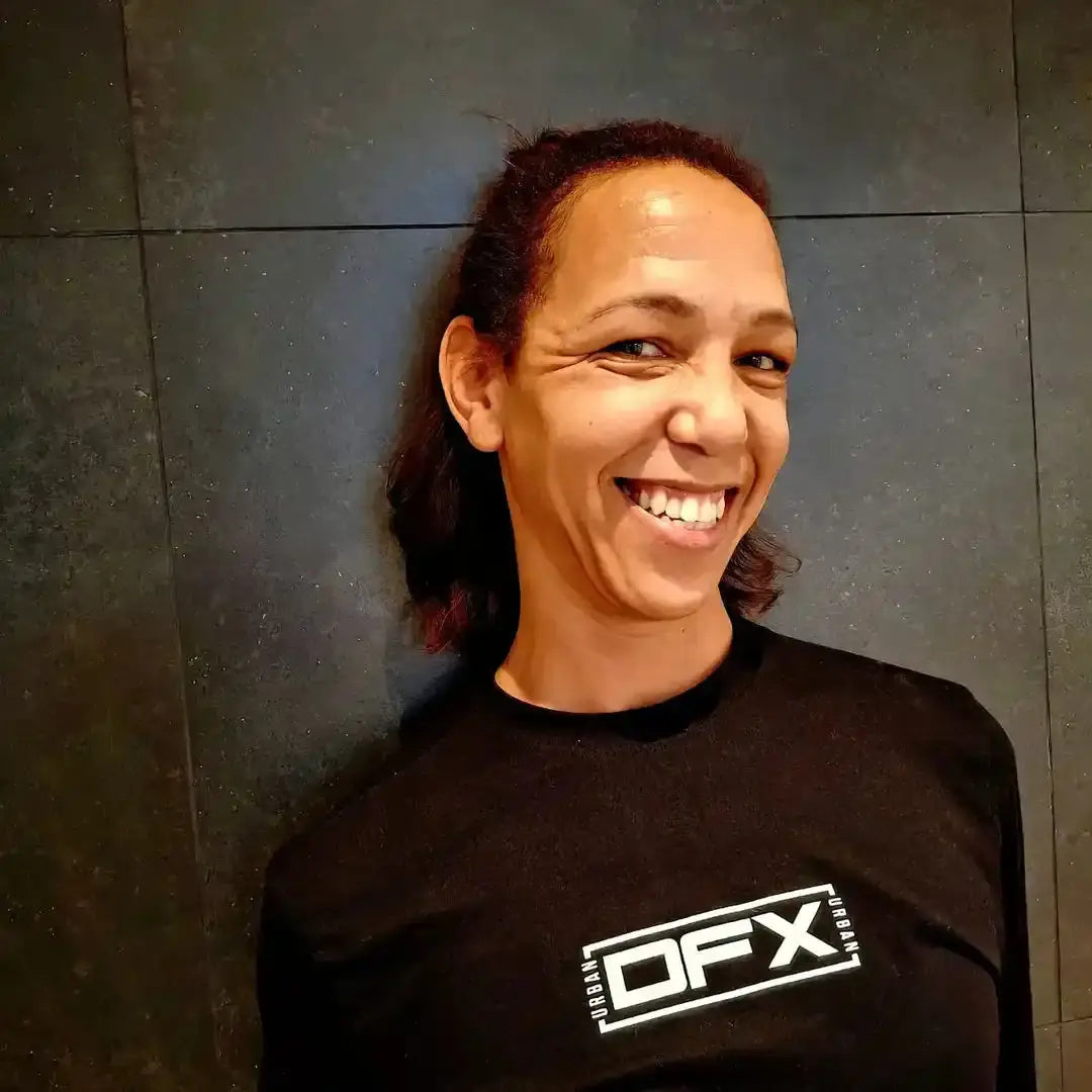 A person wearing a black DFX t-shirt with a bright smile.