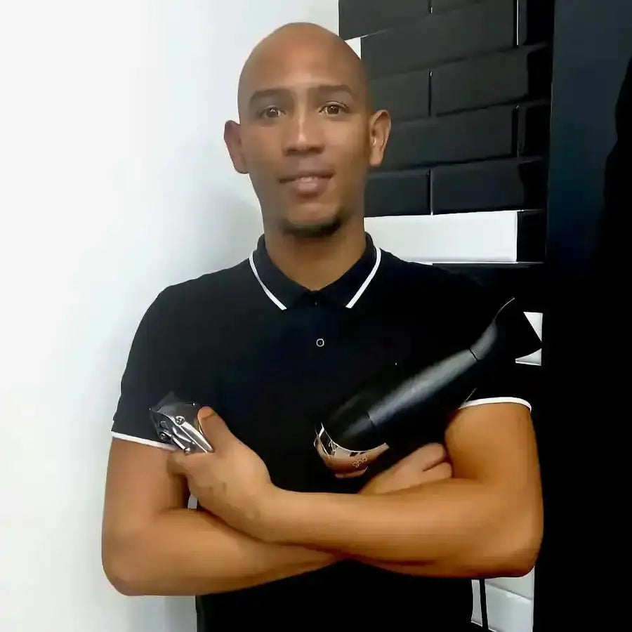 A person wearing a black polo shirt with white trim stands with arms crossed.