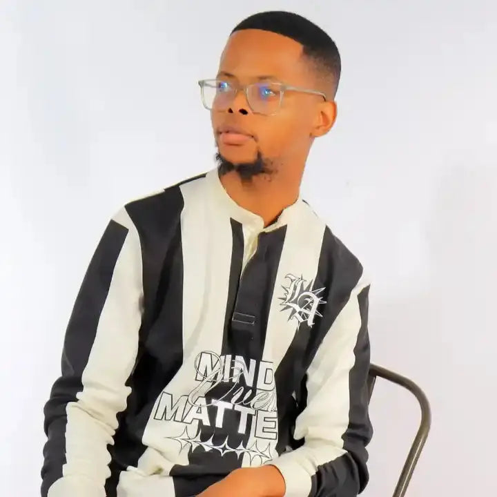 A person wearing glasses and a black-and-white striped jacket with text graphics.