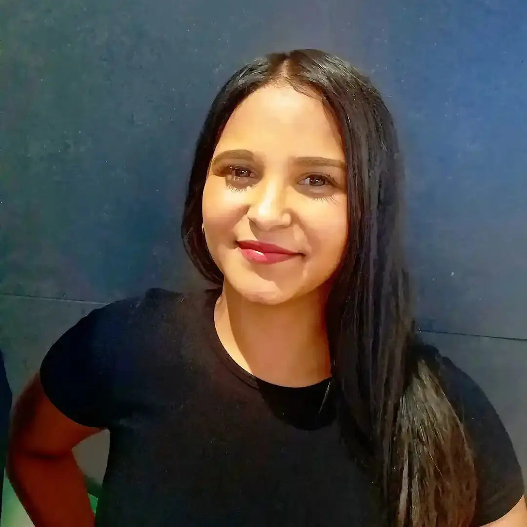 A smiling person with long dark hair wearing a black top.