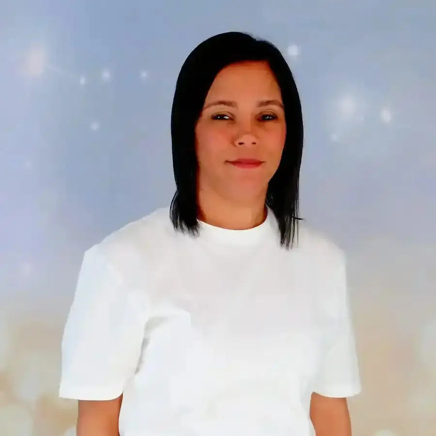 Person wearing a plain white t-shirt with straight black hair against a soft bokeh backdrop.