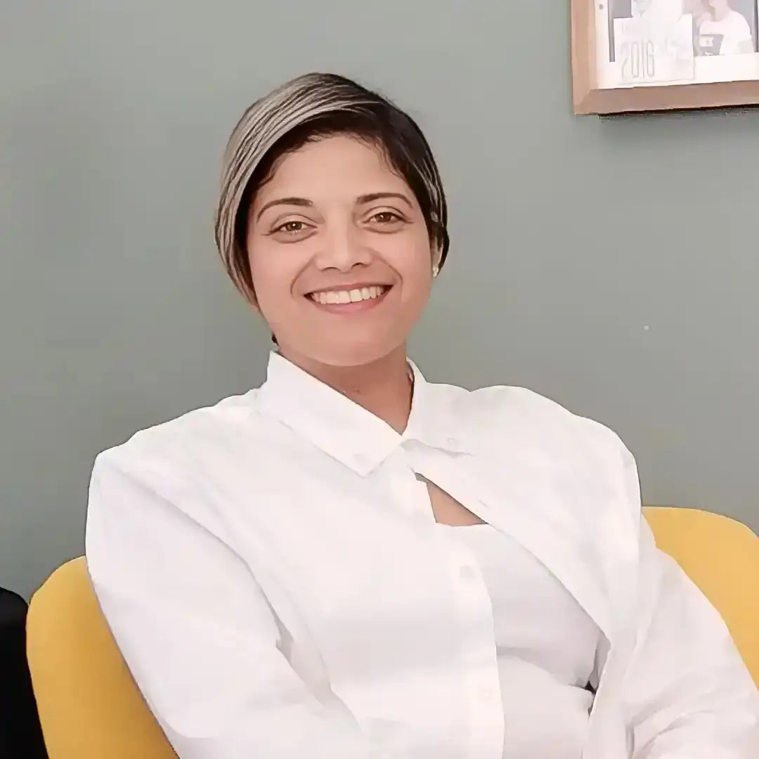 A professional wearing a crisp white button-up shirt while seated in a yellow chair.