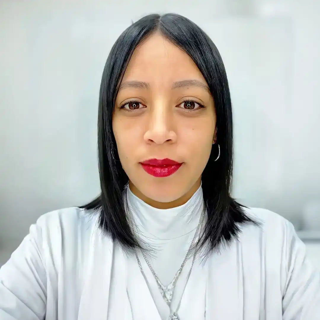 Professional headshot featuring straight black hair, bright red lipstick, and a white turtleneck sweater.