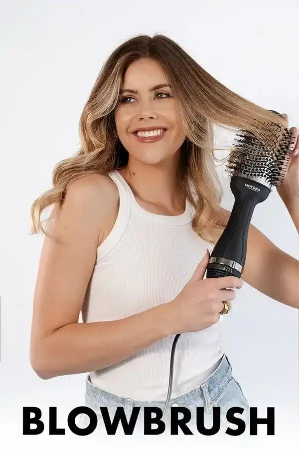 Round hairbrush with bristles held by a smiling woman.
