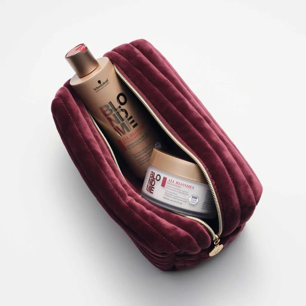 Burgundy velvet cosmetic bag or toiletry pouch containing beauty products.
