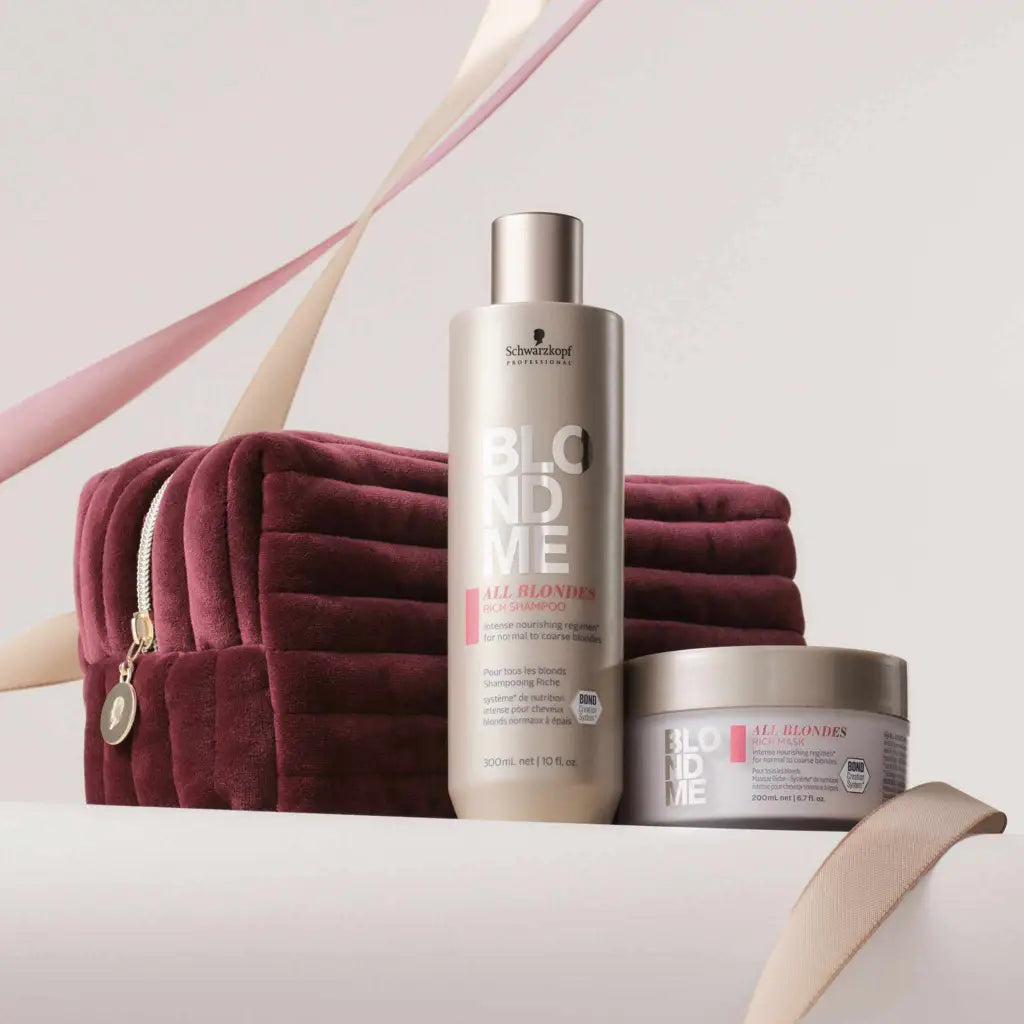 Hair care products from Schwarzkopf’s BlondMe line alongside a burgundy velvet cosmetic bag.