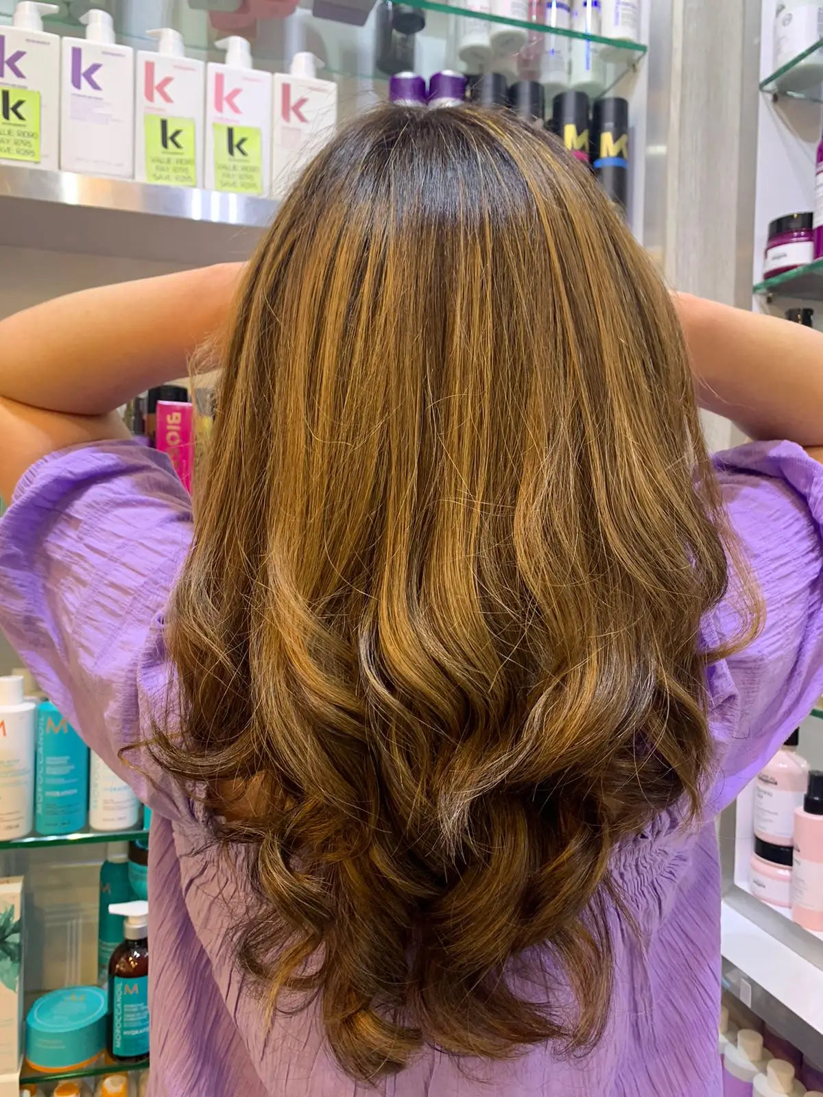 Long wavy brown hair with highlights by Partners Hair Design in Cape Town.