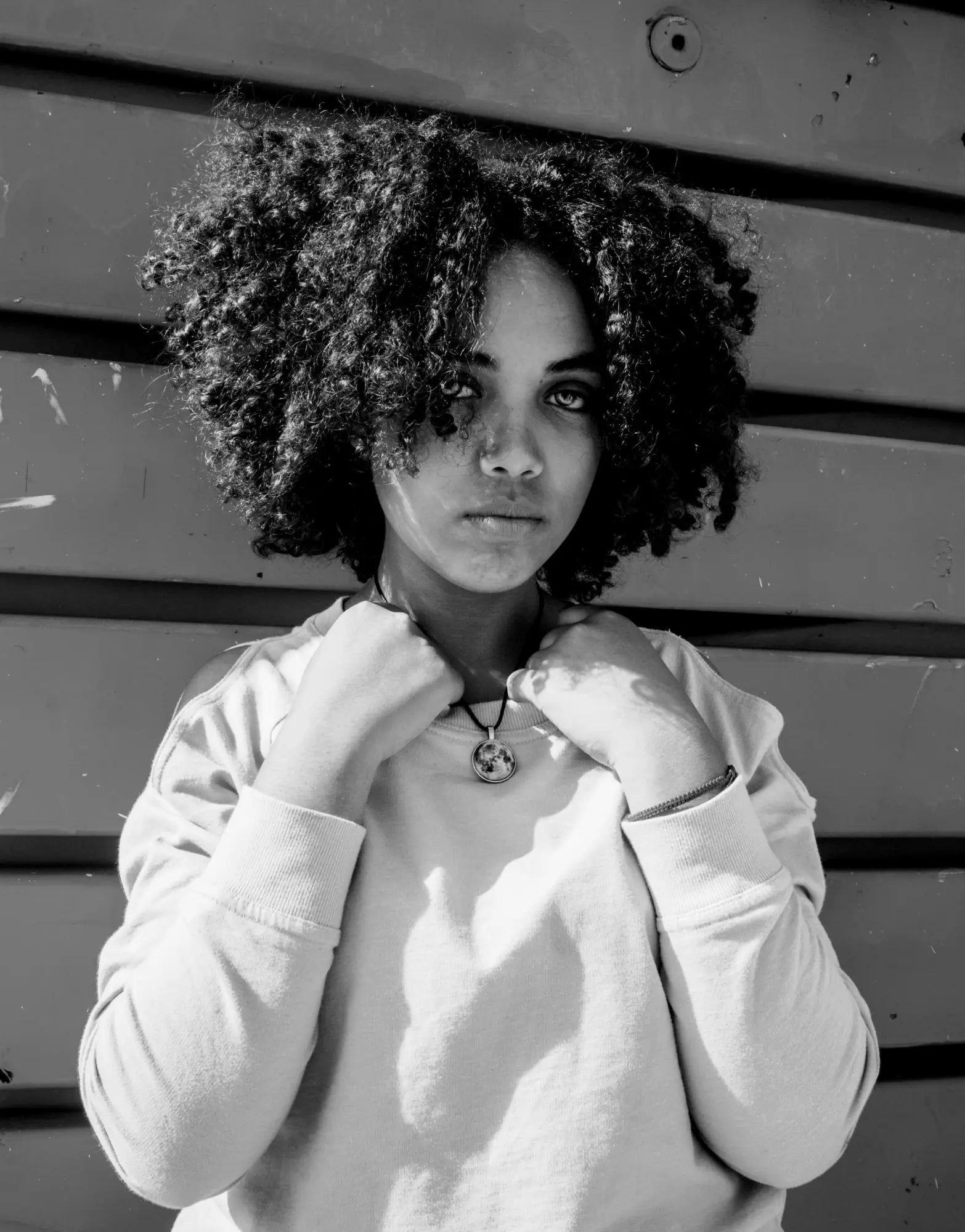 Woman with voluminous curly hair in white sweater, showcasing her natural curl pattern.