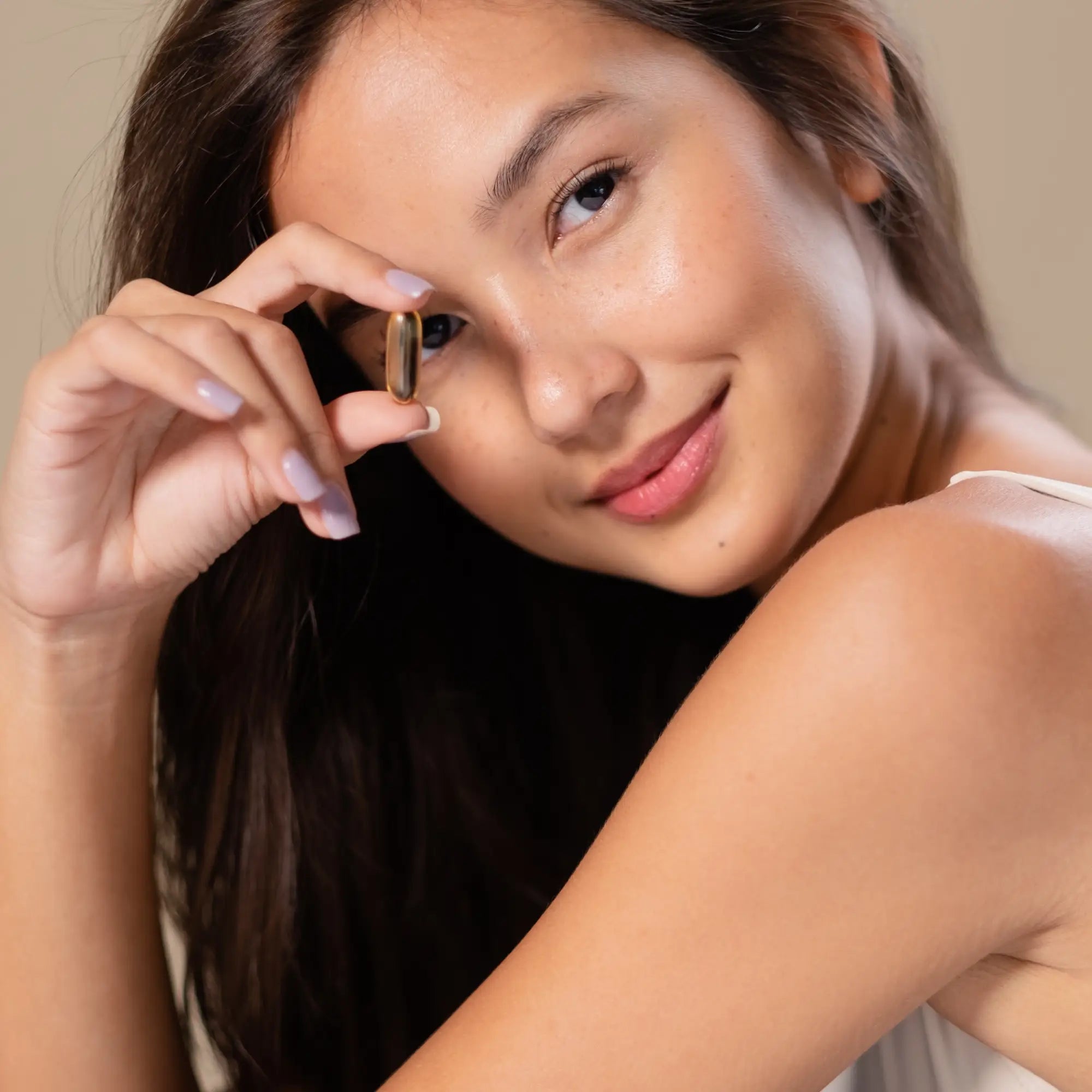 Woman with long dark hair holding Hannon anti-hair loss product for healthy growth.