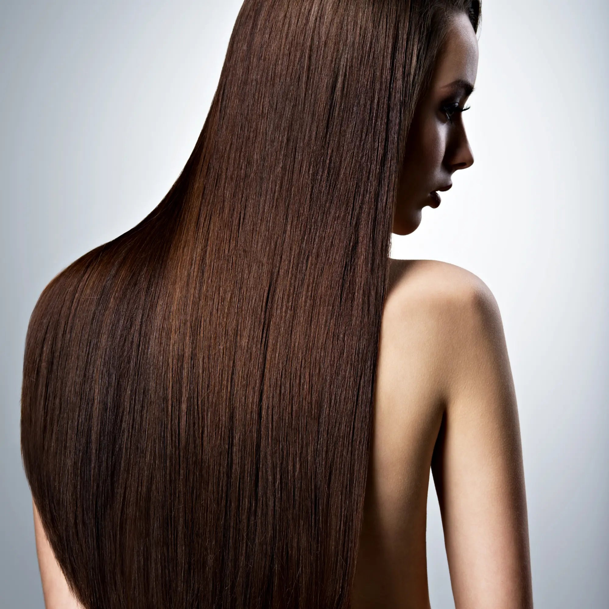 Long, shiny brown hair cascading down a back, highlighting keratin treatments for hair care.