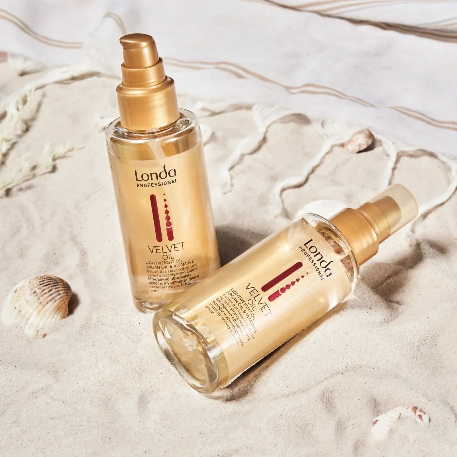 Gold-colored glass bottles of Kadus Velvet Oil for professional hair care with Fiber Infusion.