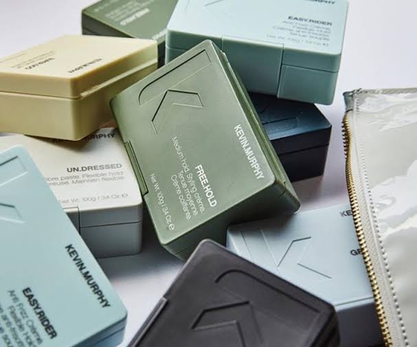 Metal business cards in muted colors showcasing Kevin Murphy hair styling brand.