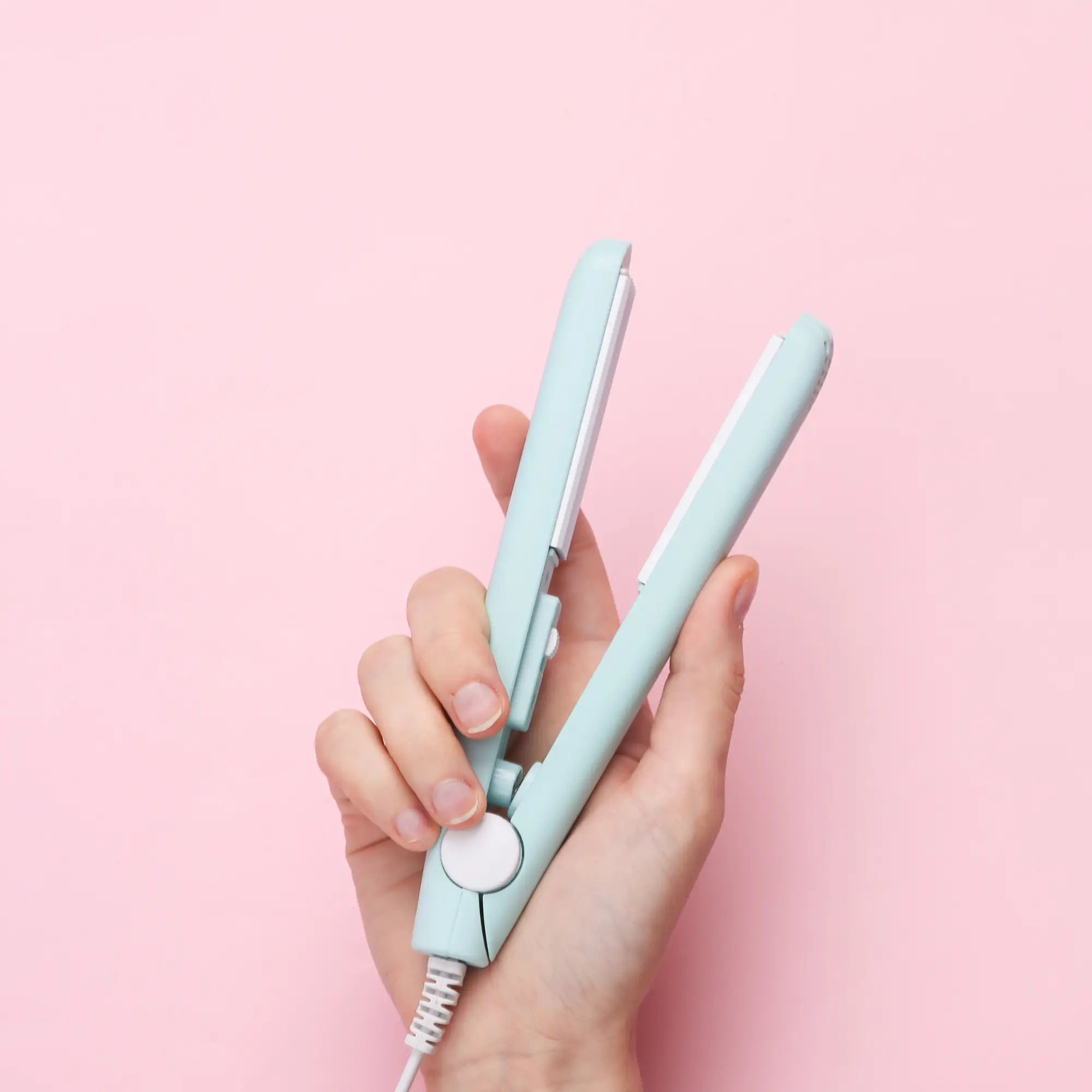 Mint green Moyoko Infinity Styler in hand, showcasing effective heat distribution.