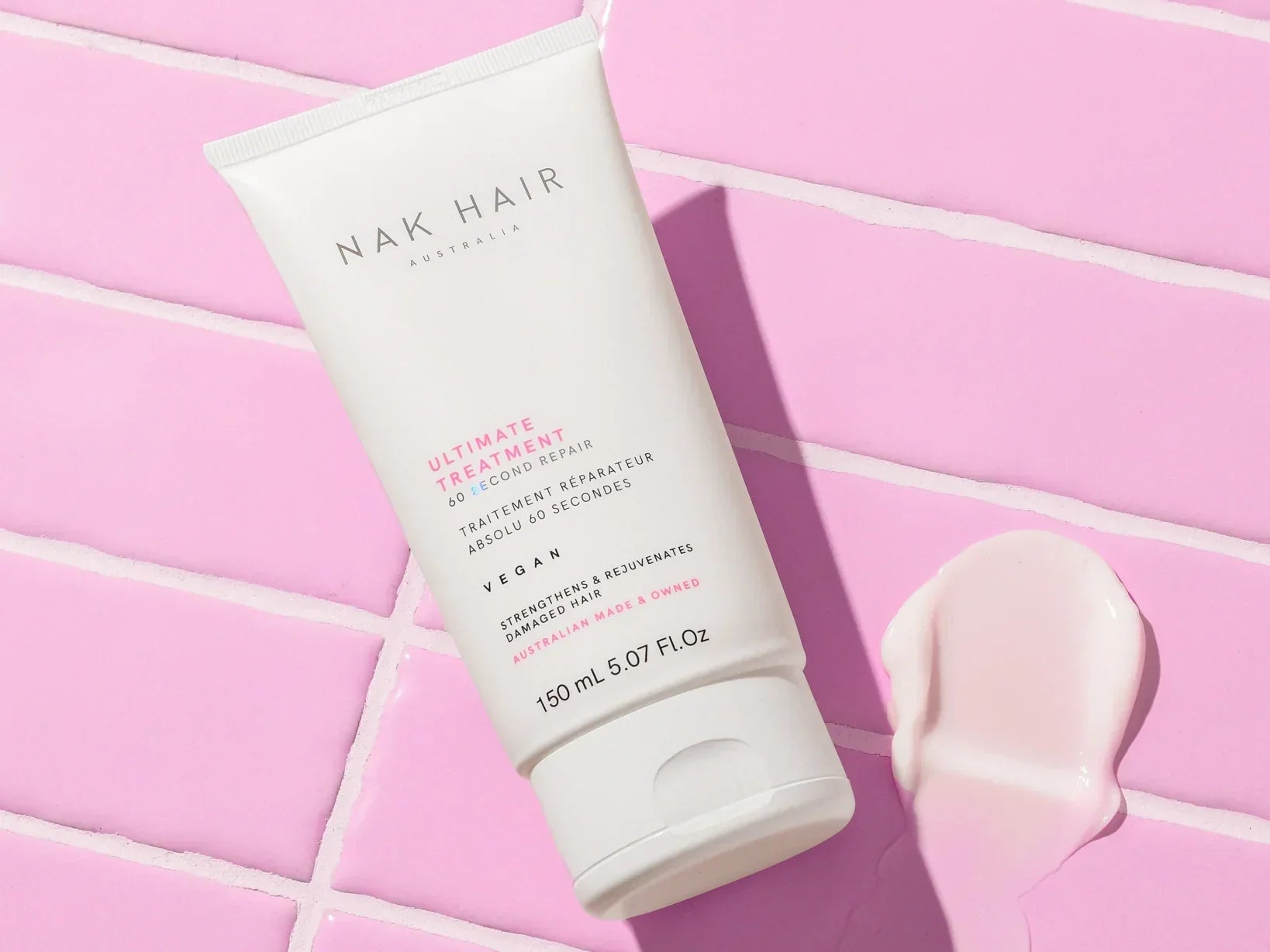 White NAK Hair product tube on a pink surface showcasing NAK Volume Shampoo benefits.