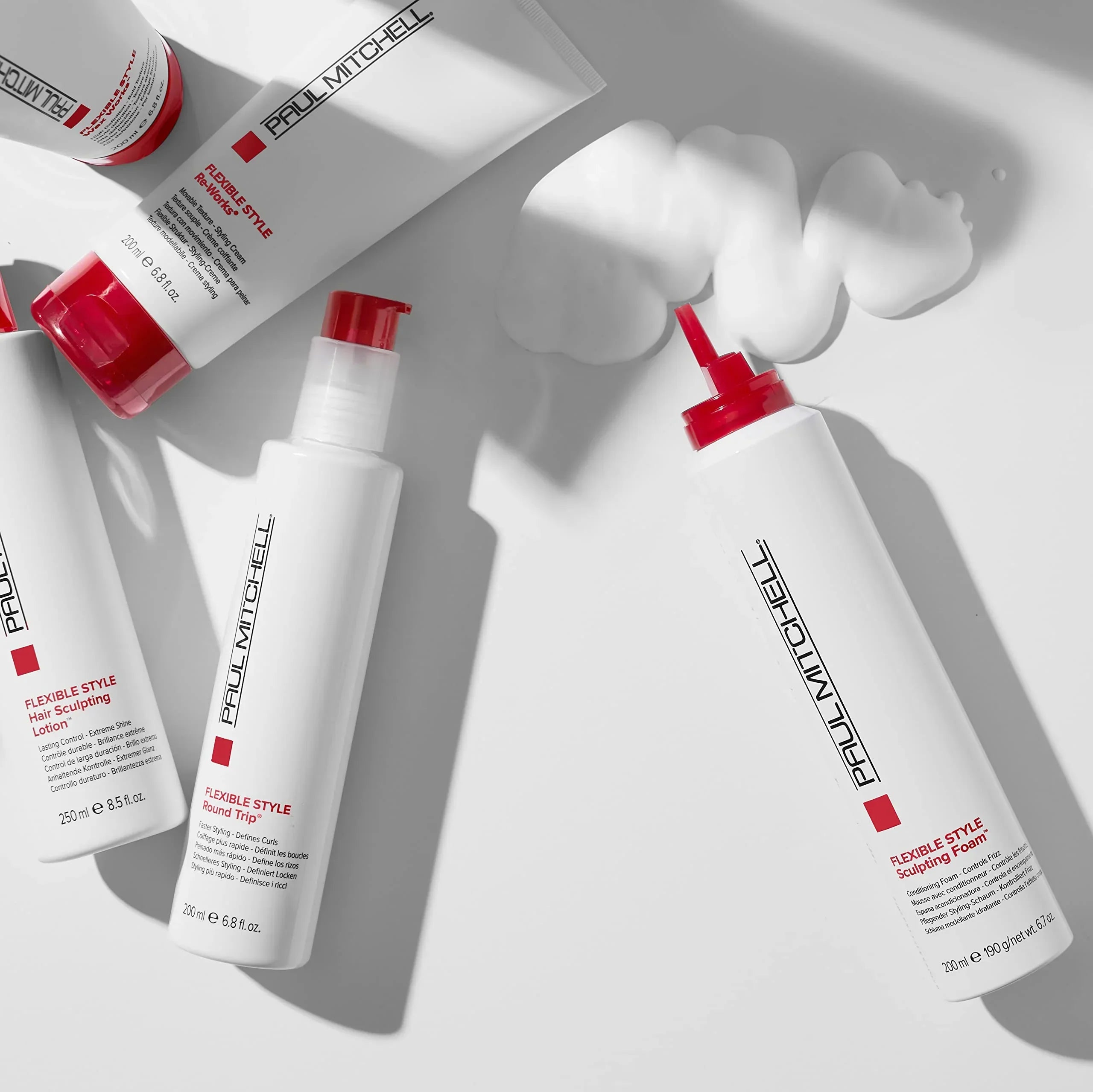 Paul Mitchell hair care products in stylish white bottles with red accents.