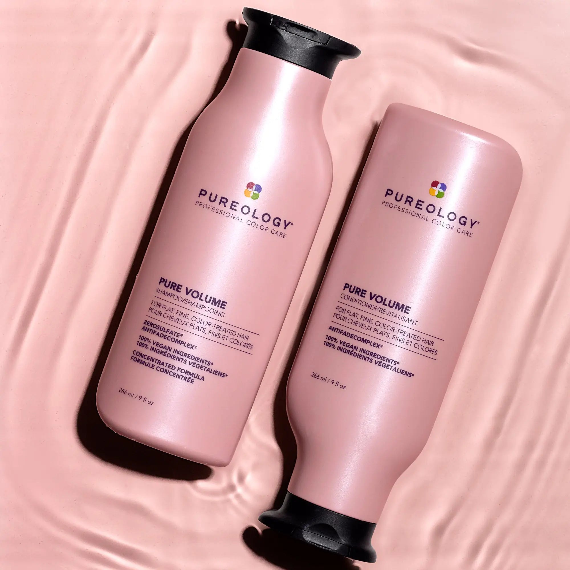 Two pink Pureology conditioner bottles for taming unruly hair.