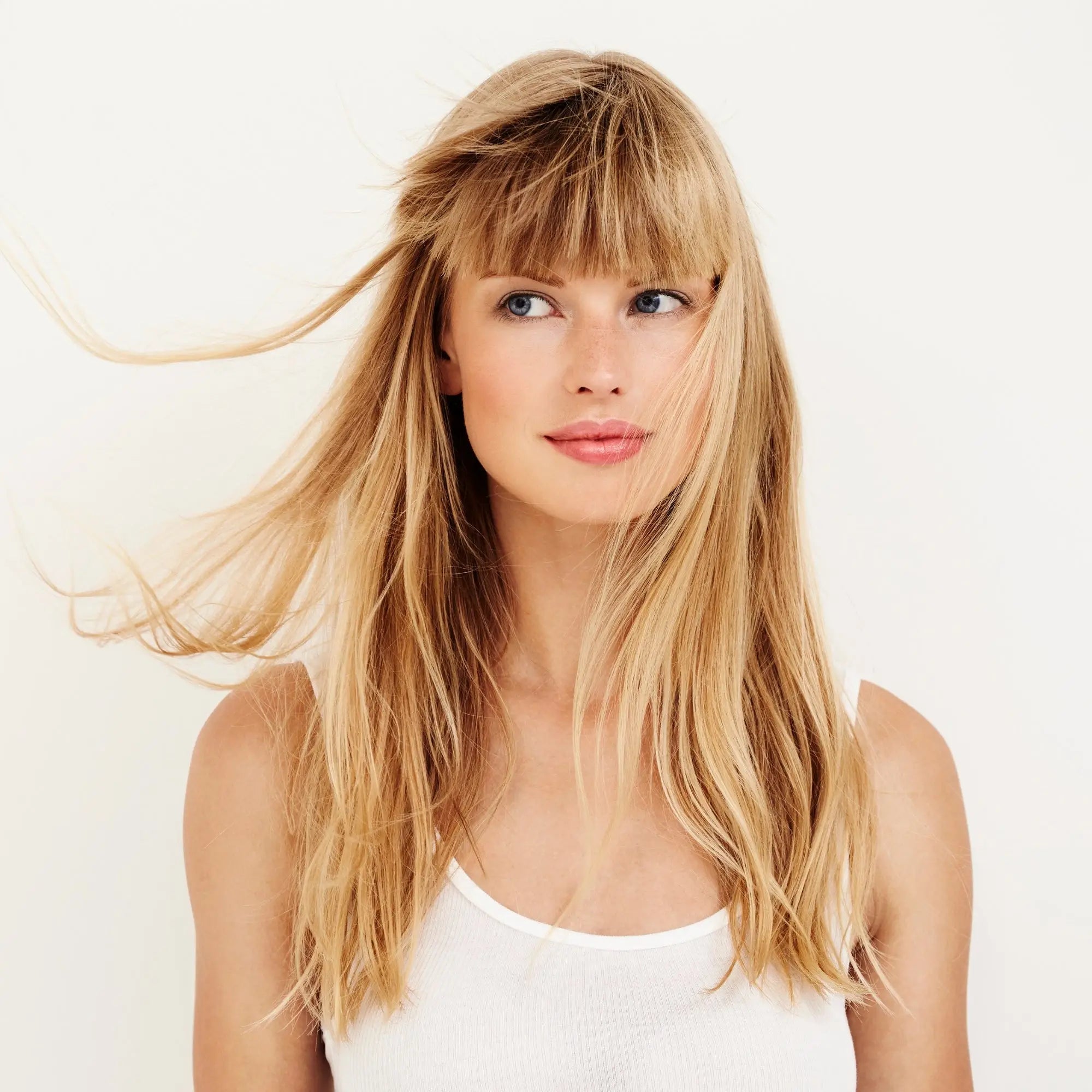 Young woman with long blonde hair using sulfate-free purple shampoo for brassy locks