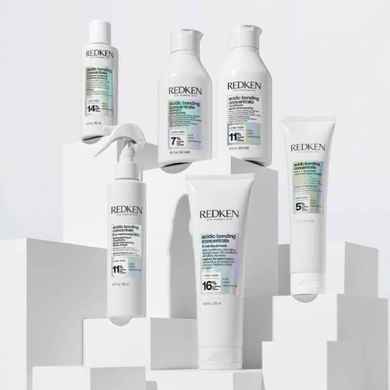 Collection of Redken hair care products showcasing Acidic Bonding Concentrate on geometric shapes