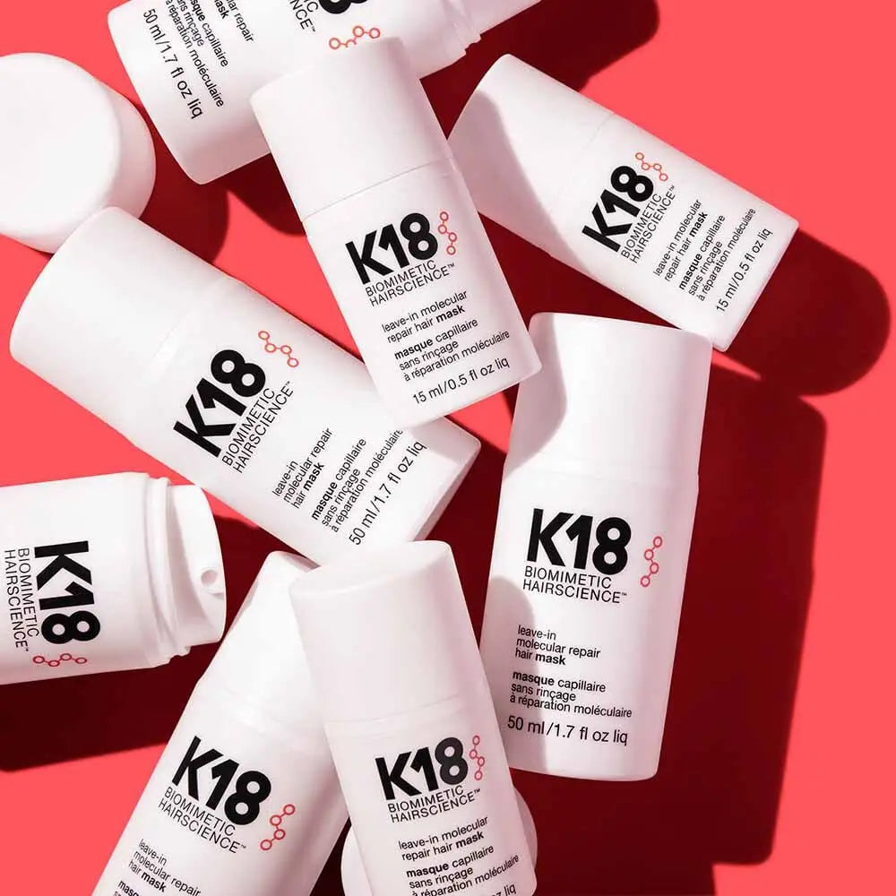 White K18 hair care bottles on a red surface featured in South Africa article.