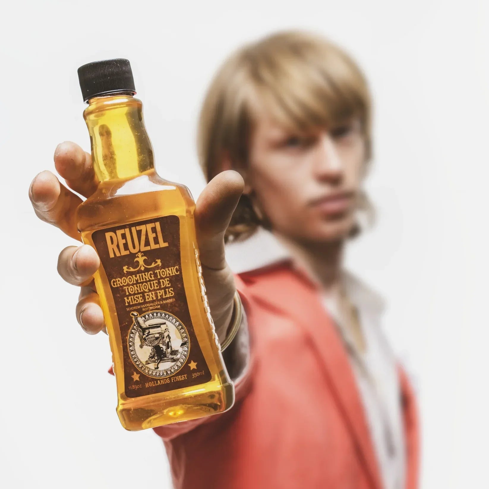 Bottle of Reuzel grooming tonic showcasing the brand’s rich history and global phenomenon.