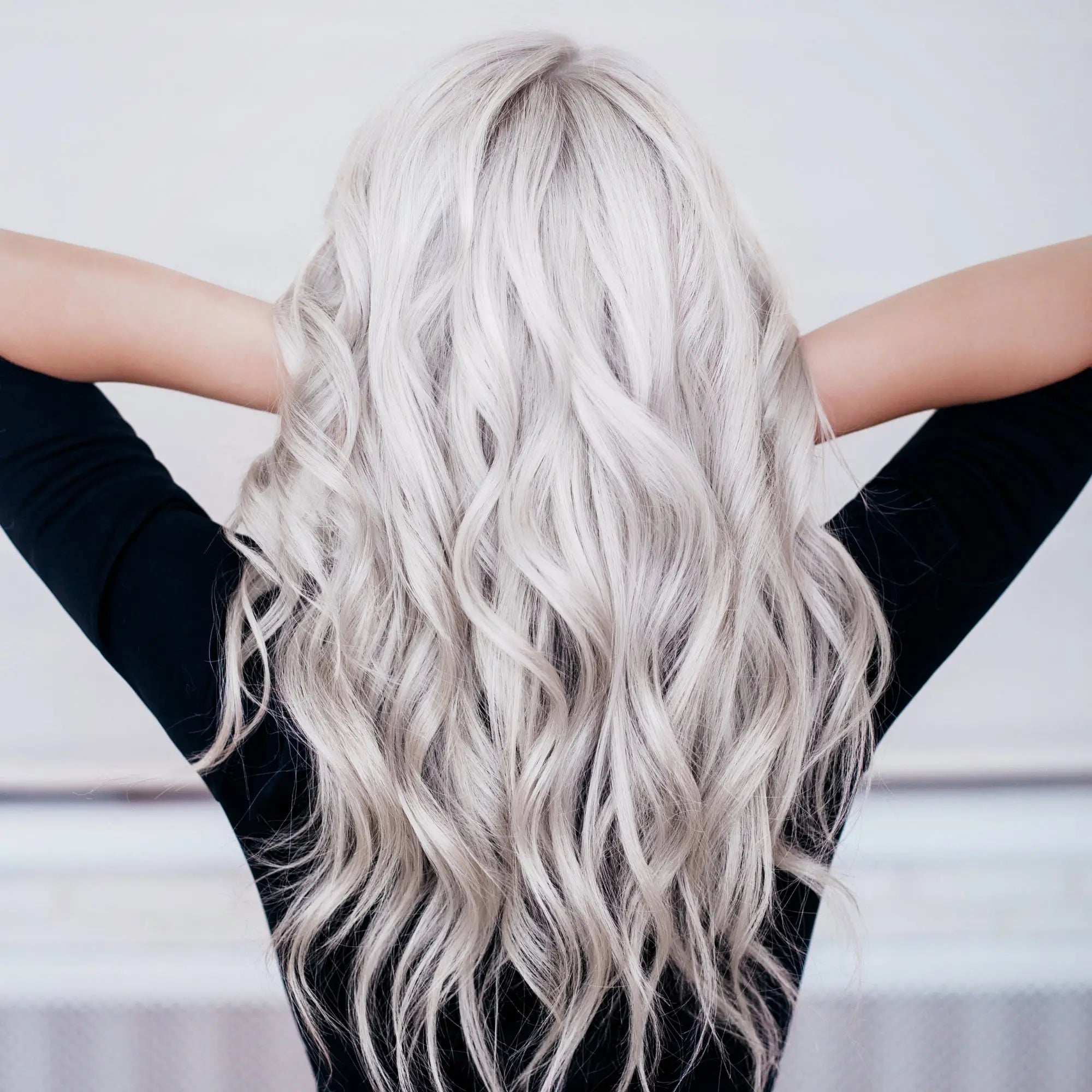 Long wavy platinum blonde hair showcasing natural highlights with silver shampoo results.