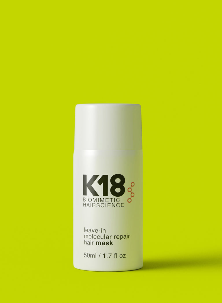 K18 leave-in hair mask bottle on bright green background for damaged hair revival.