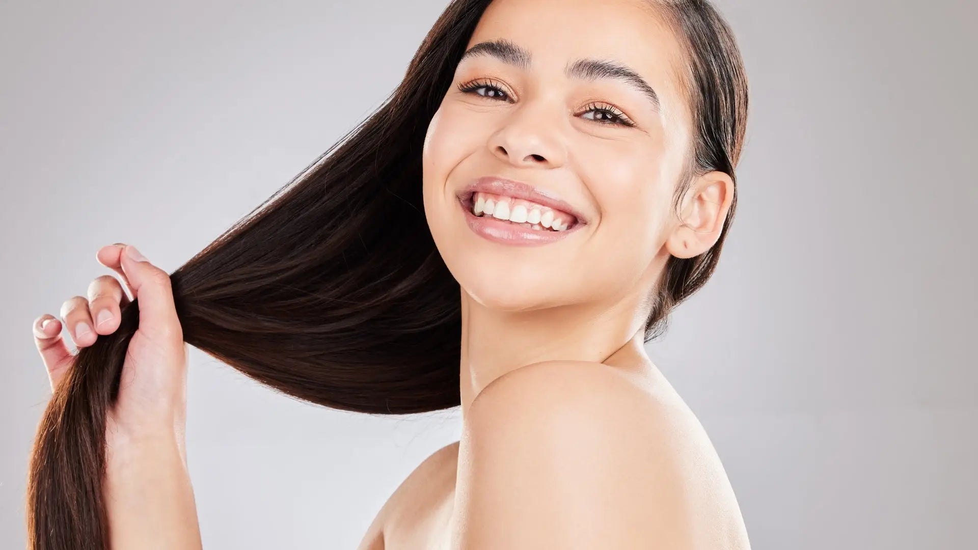 Smiling woman with long dark hair showcasing vibrant partners hair design techniques.