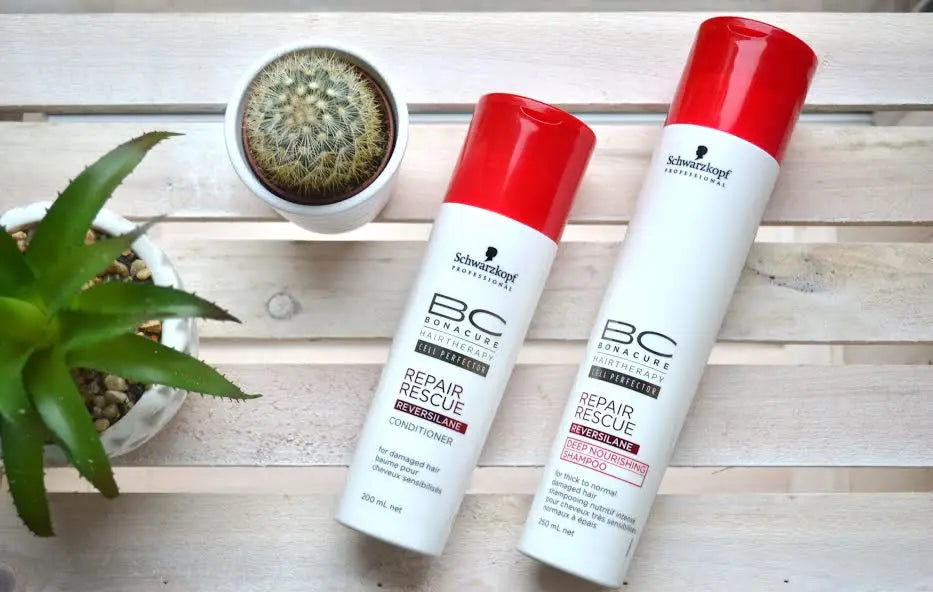 Two red-capped Schwarzkopf shampoo bottles for color-treated hair with natural oils.