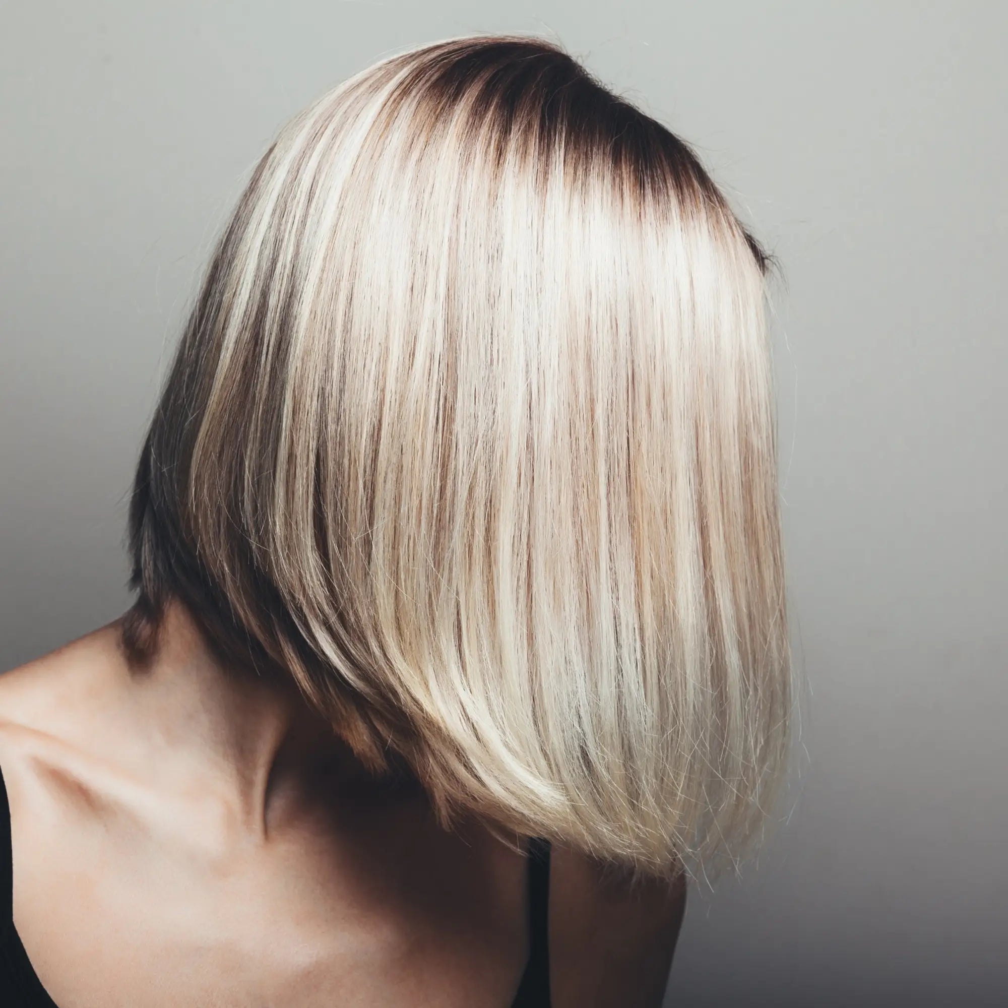 Sleek blonde bob hairstyle with dark roots for stunning short hair styles and defined looks