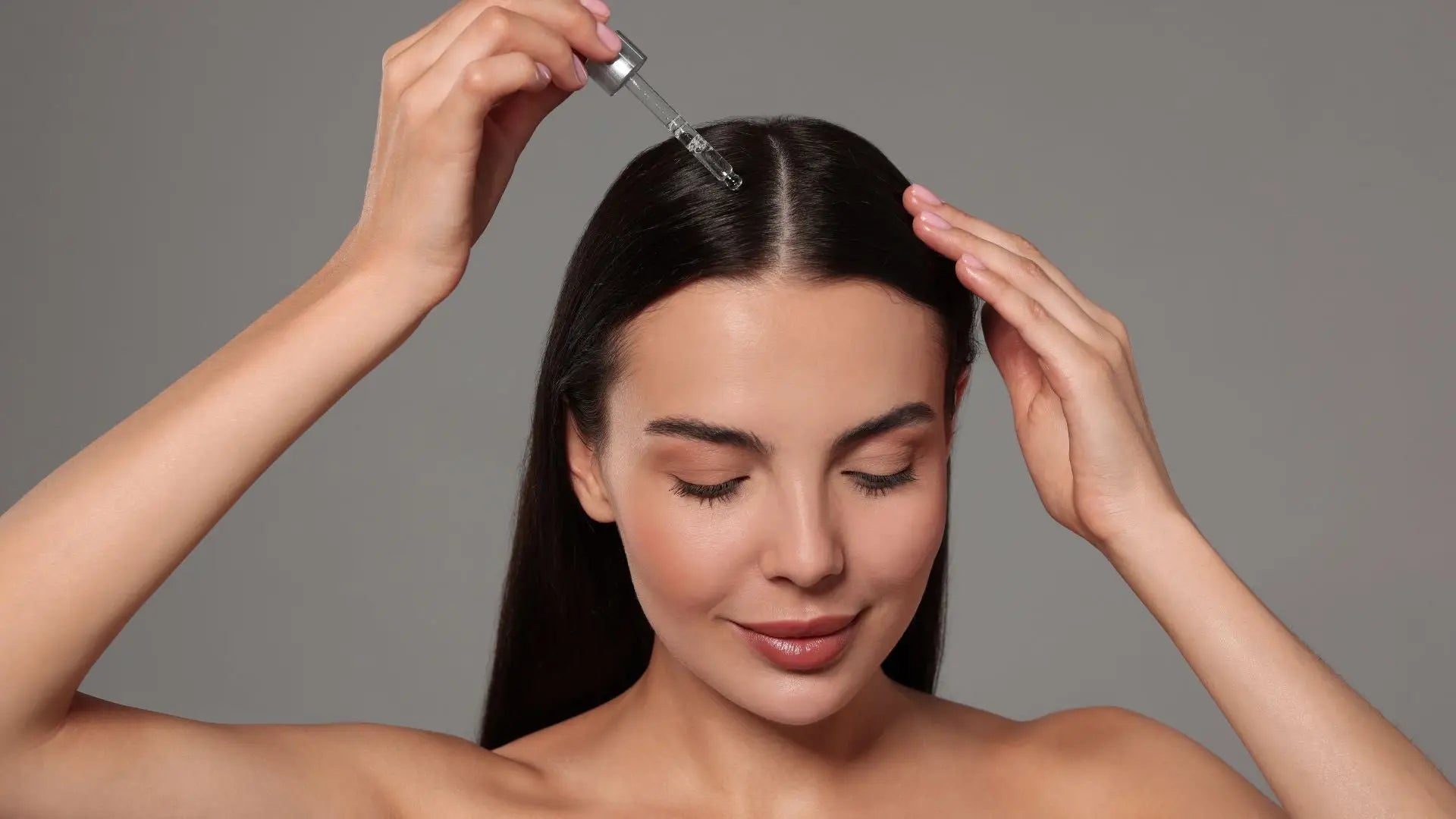 Woman with long dark hair applying sulfate-free shampoos for scalp health.