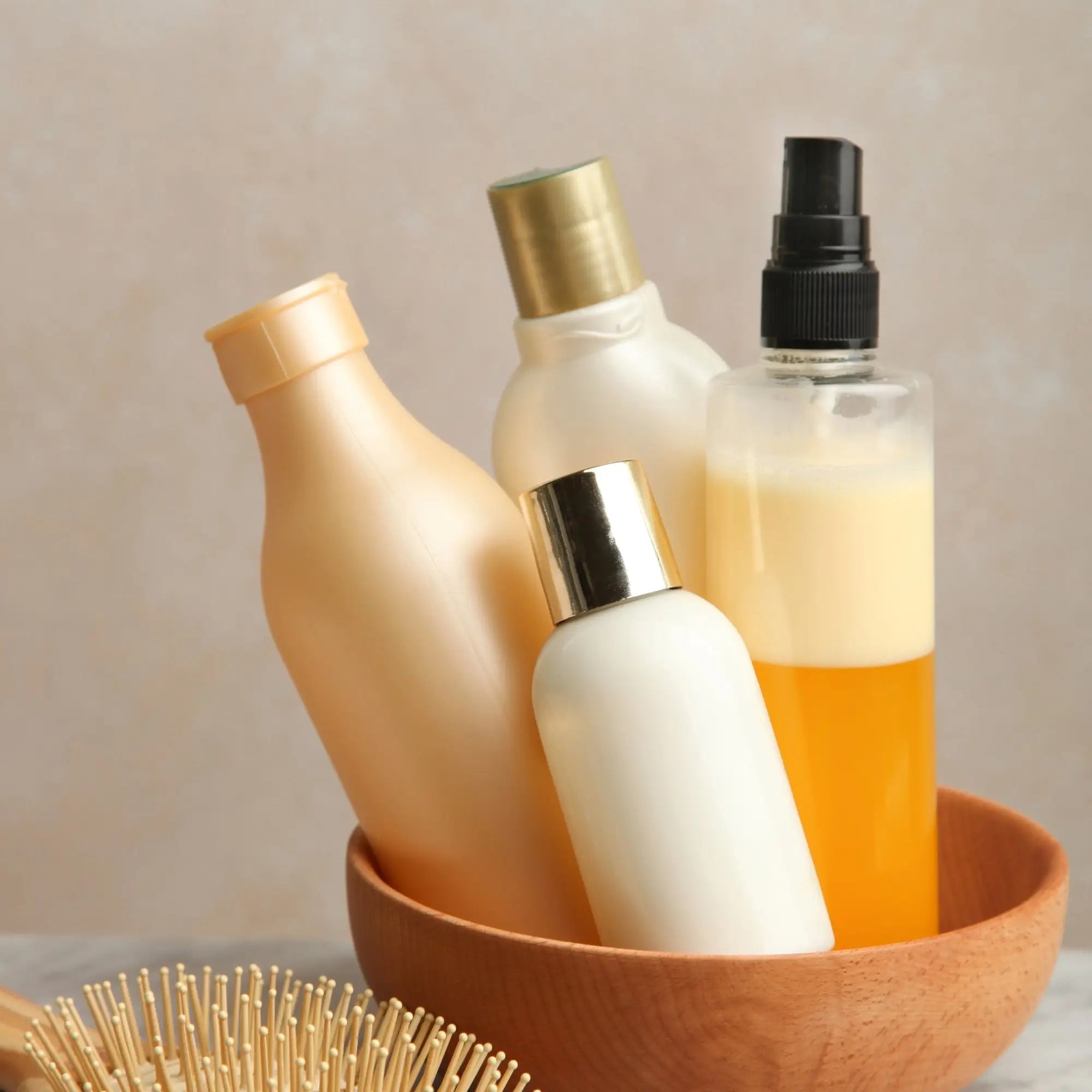 Collection of skincare and cosmetic bottles in a terracotta bowl for hair care.