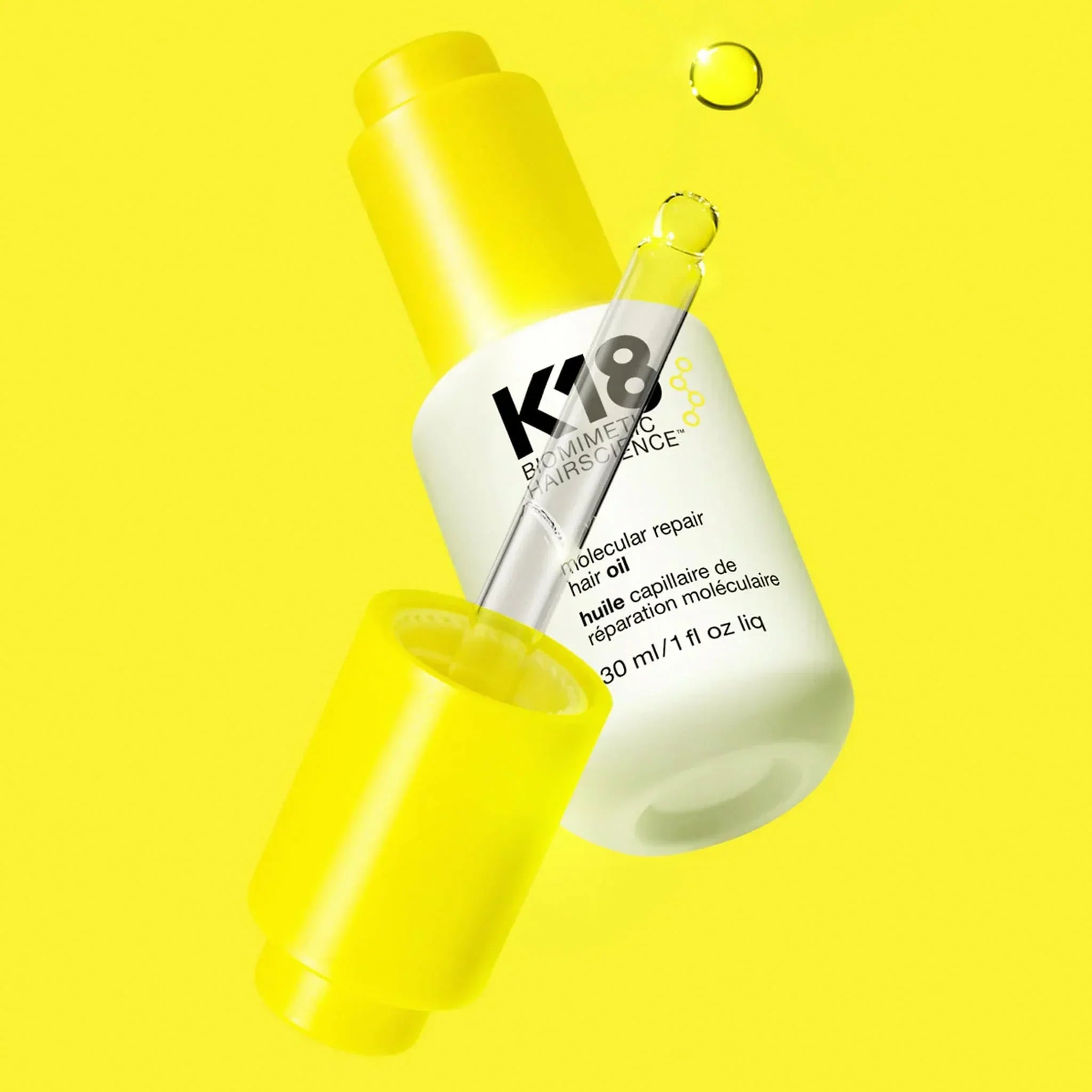 White K18 molecular repair hair care bottle with dropper surrounded by yellow tones.