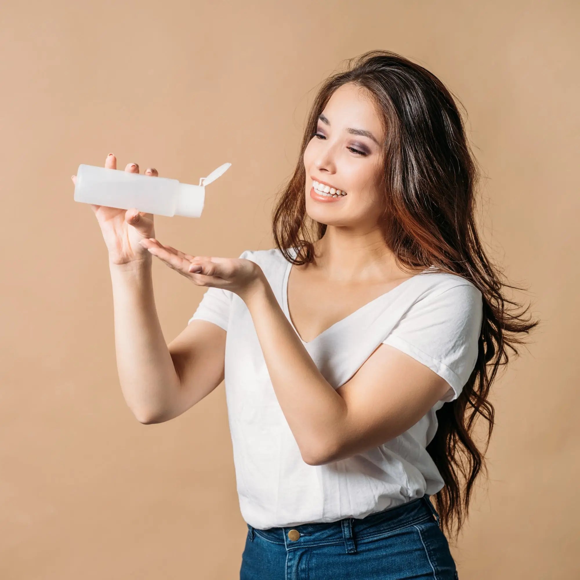 Woman with long dark hair holding a sulfate-free shampoo for healthy hair transformation.