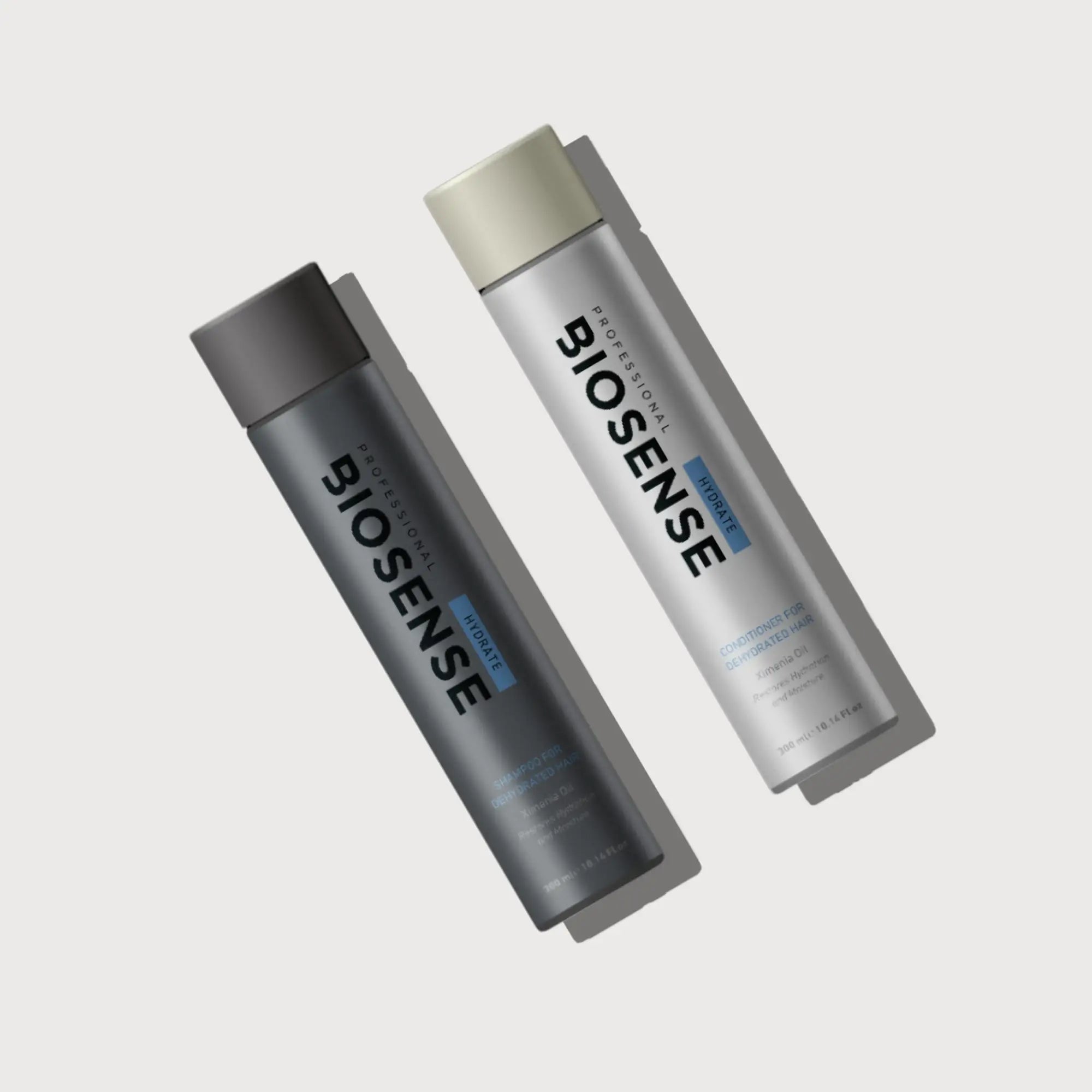 Two cylindrical Biosense Hydrate bottles in dark gray and light silver for healthy hair.