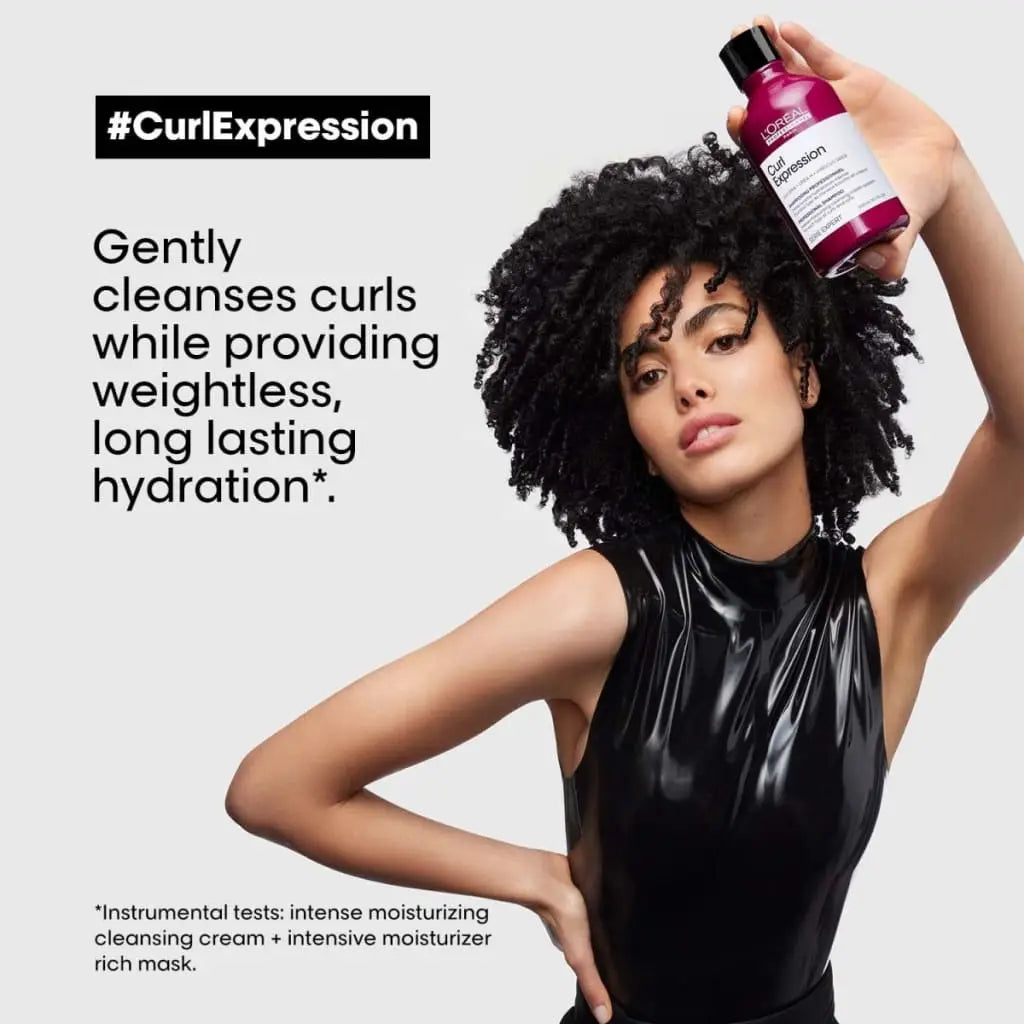 Woman with curly hair holds L’Oréal Curl Expression curls reviver in advertisement.