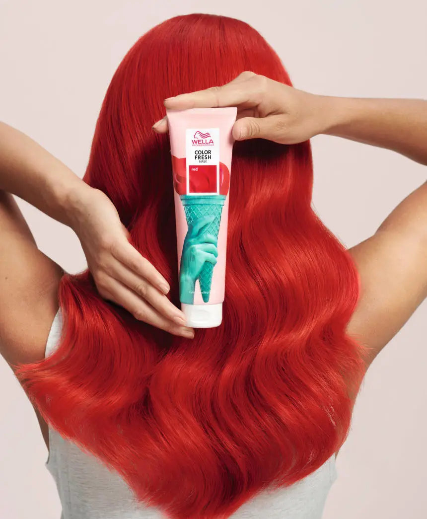 Vibrant red hair with long wavy locks showcasing Wella Professionals color innovation.