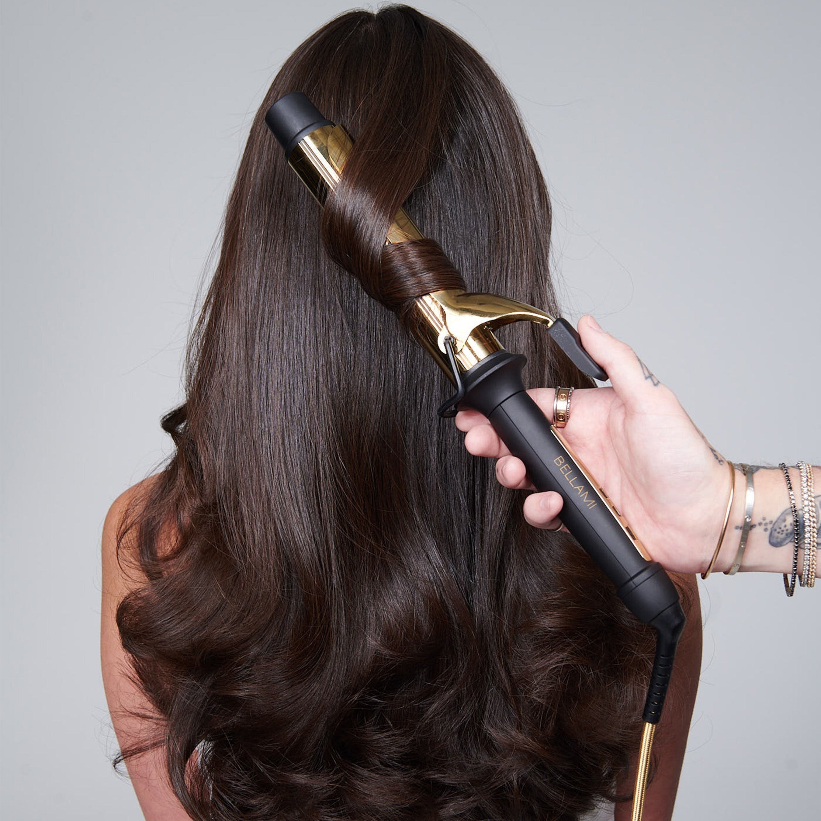 Hair being curled with a gold and black curling iron for perfect curls and waves