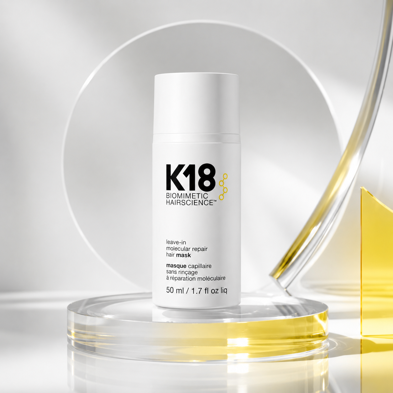 K18 molecular repair hair care bottles in white packaging with pink background.