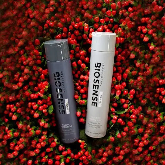 Two bottles of Biosense hair care products with red berries. Shop Biosense shampoo and conditioner.