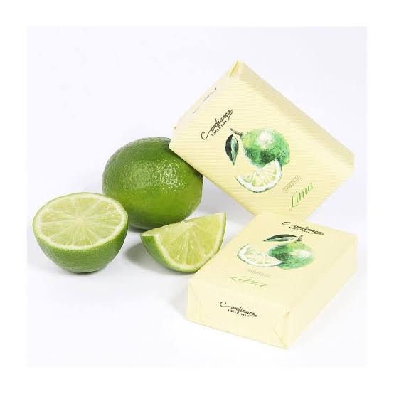 Fresh lime fruits and Confianca Body Soap packaging in a vibrant display.